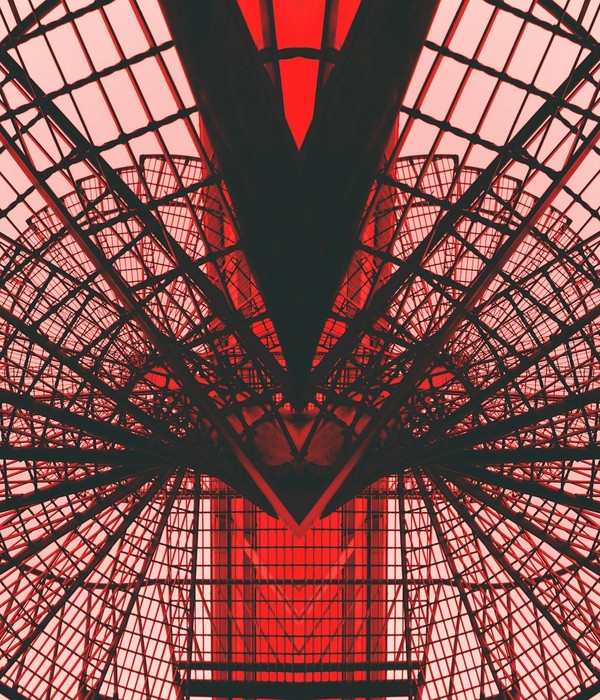 Abstract view of a red geometric architectural structure, showcasing modern design and symmetry.